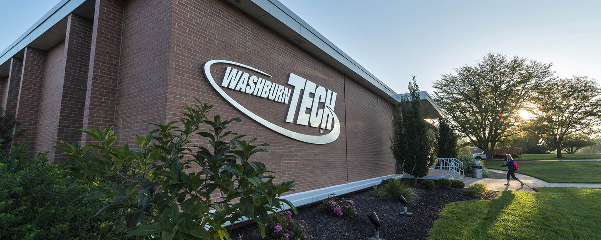 Washburn tech sign on building with woman walking into building.