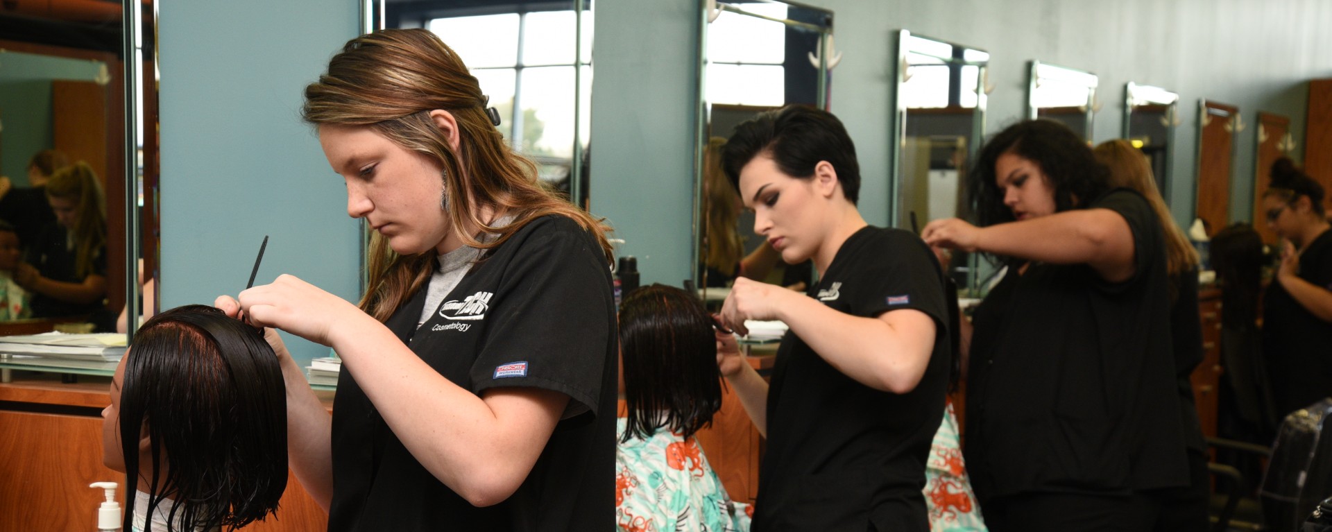 three cosmetology students on the floor