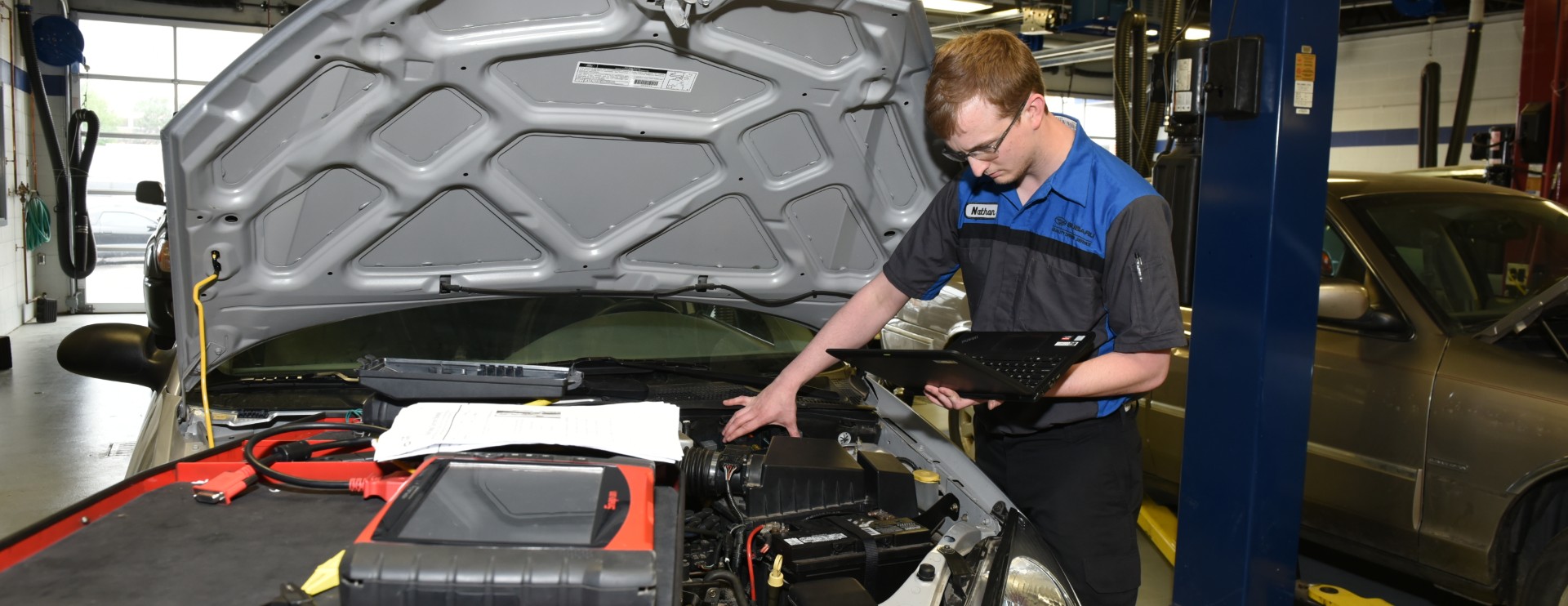 student working on car engine