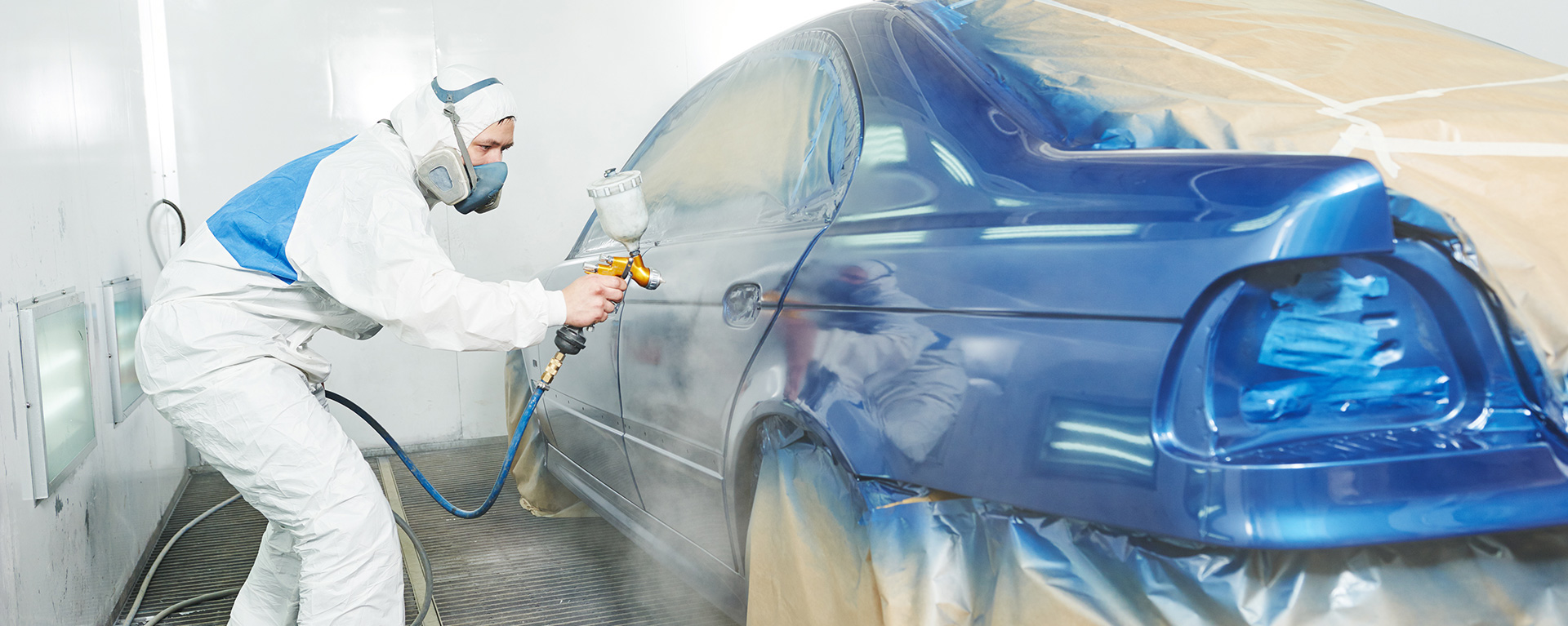 auto collision student in a paint booth