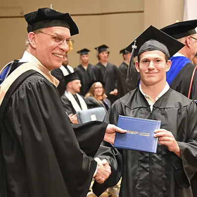 A Washburn Tech graduate shakes hands with the Dean.