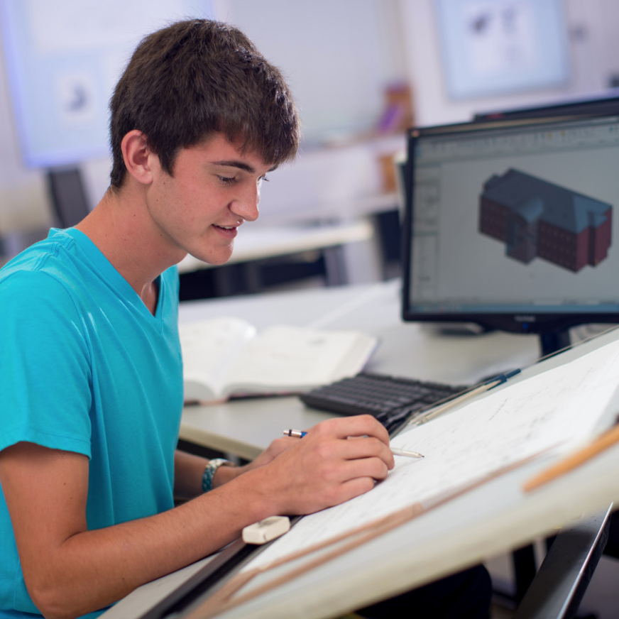 boy sitting at drafting table