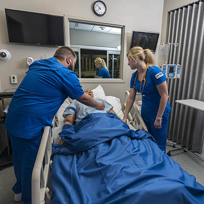 students with test patient on hospital bed