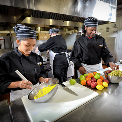 three culinary students in kitchen