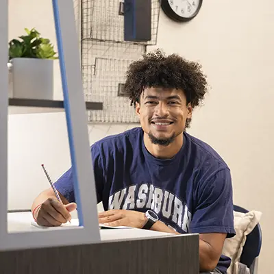 A student studies in their dorm room on campus.