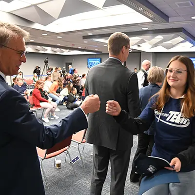 student fist bumps instructor on signing day