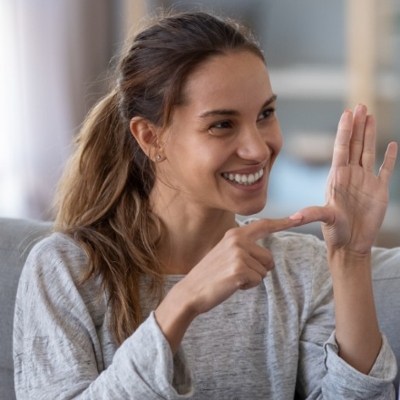 student smiling and using sign language